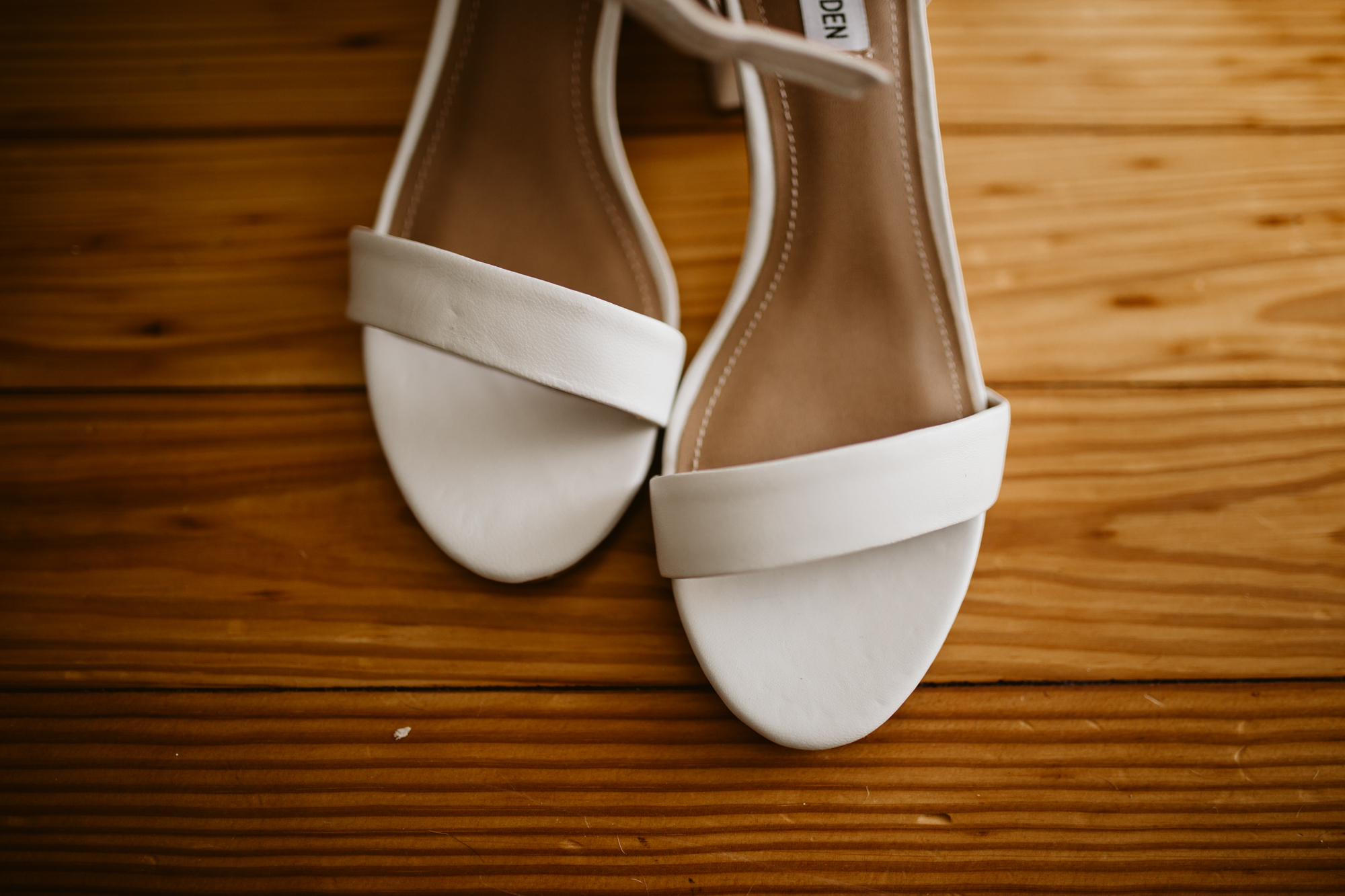 Bride's wedding shoes on the wooden floors of stone house of st charles