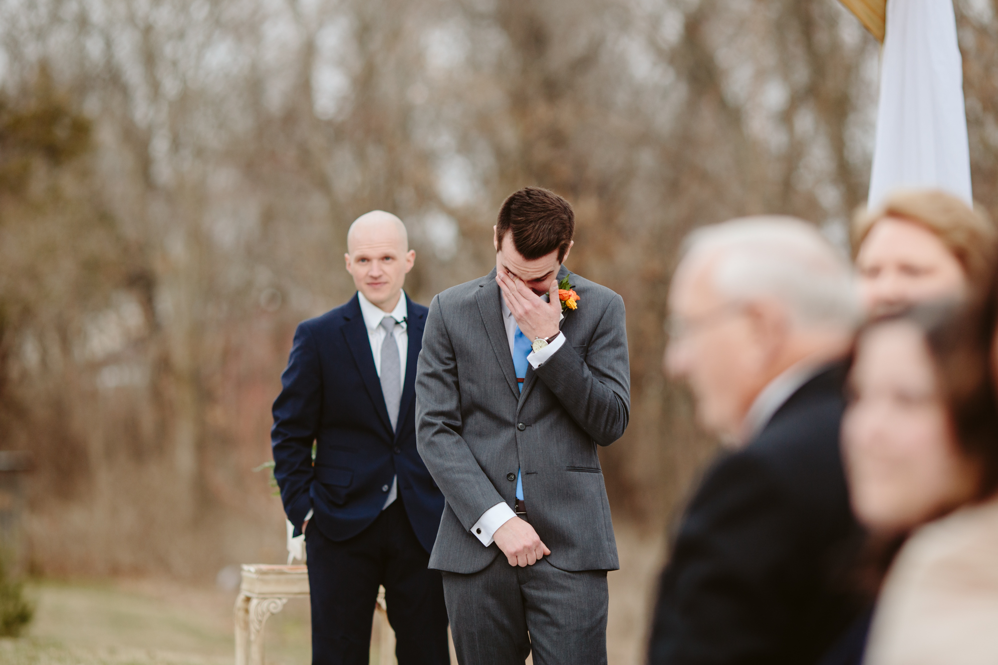 Groom seeing his bride for the first time down the aisle outside at the stone house of st charles wedding venue