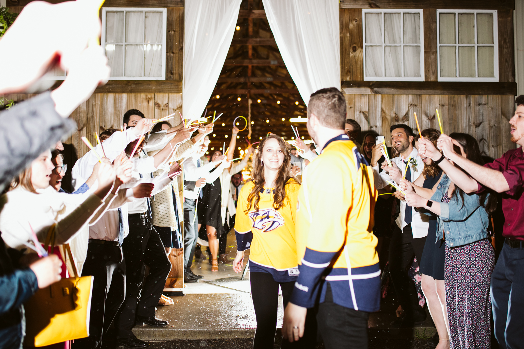 A Nashville predators themed Glow stick exit after a rustic wedding at Barn in the Bend in Nashville, Tennessee