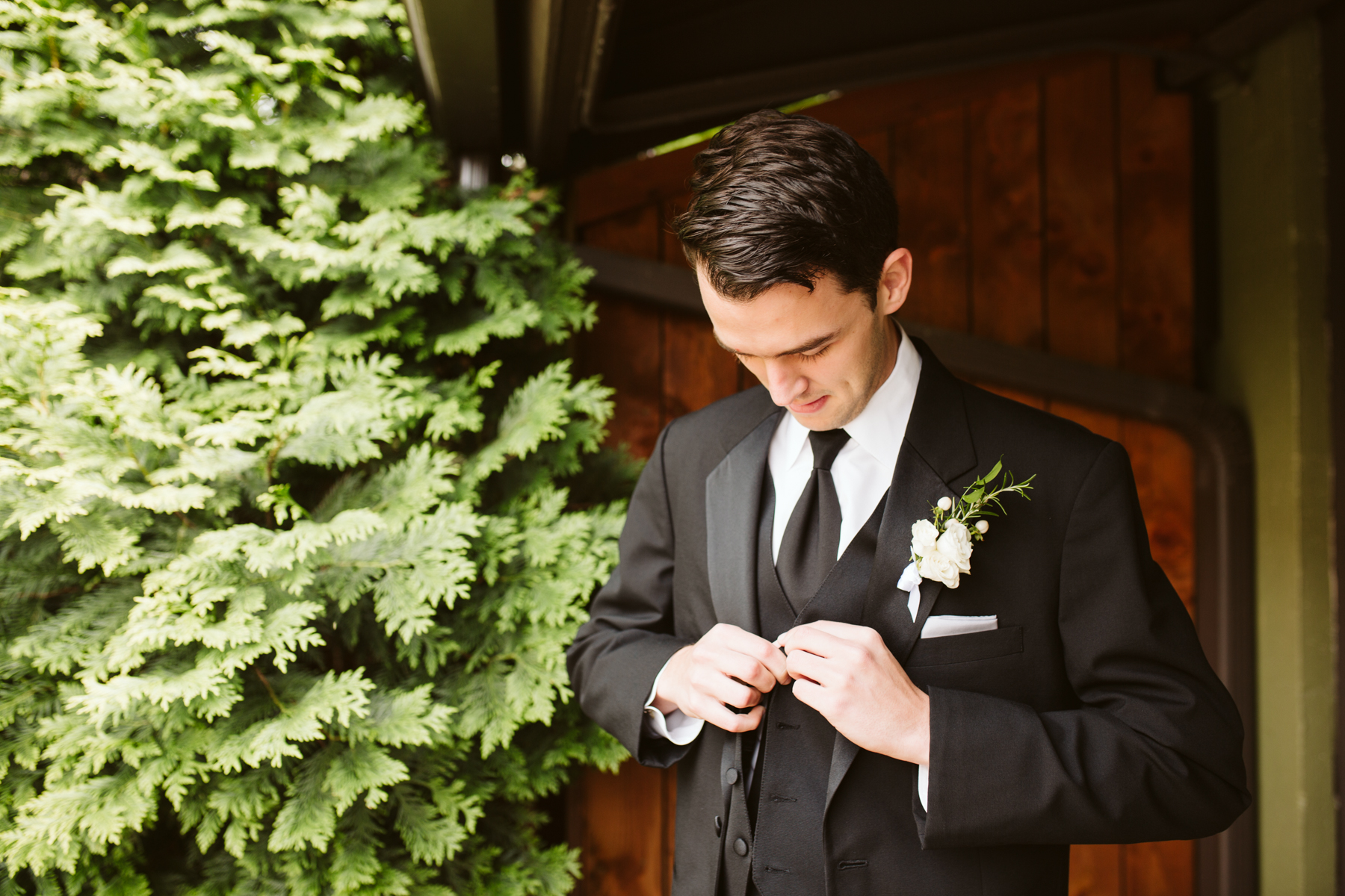 groom buttoning his jacket before a rainy summer wedding at brentwood hills church in Nashville, tennessee