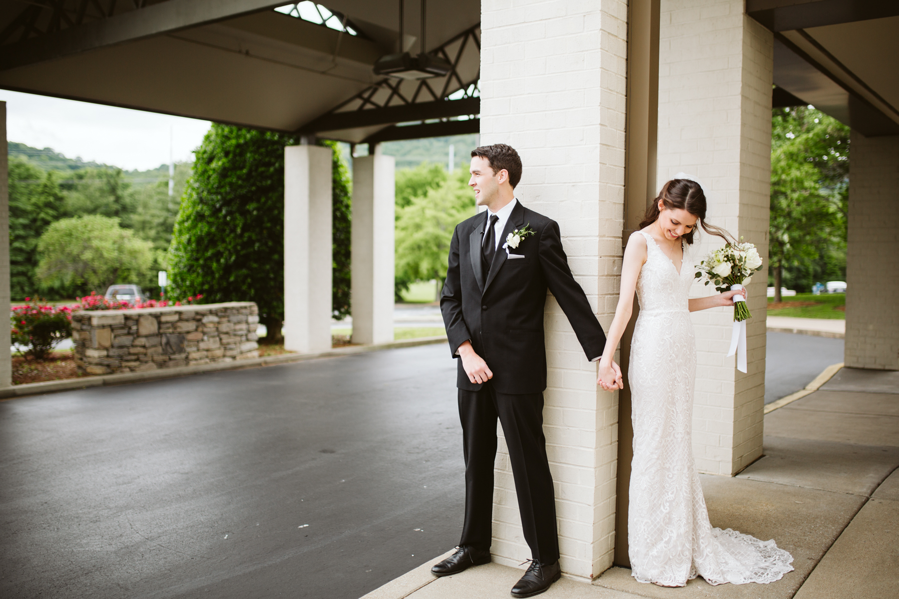bride and groom pray around a corner together before their rainy summer wedding at brentwood hills church in Nashville, tennessee