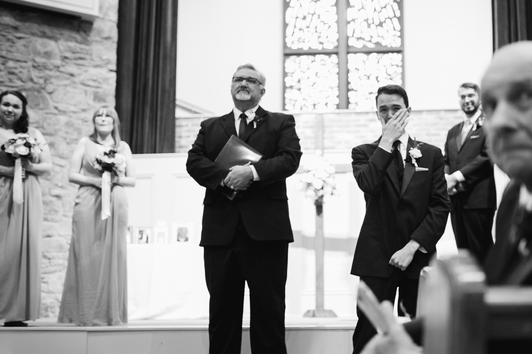 Groom seeing his bride for the first time down the aisle at a rainy summer wedding at brentwood hills church in Nashville, tennessee