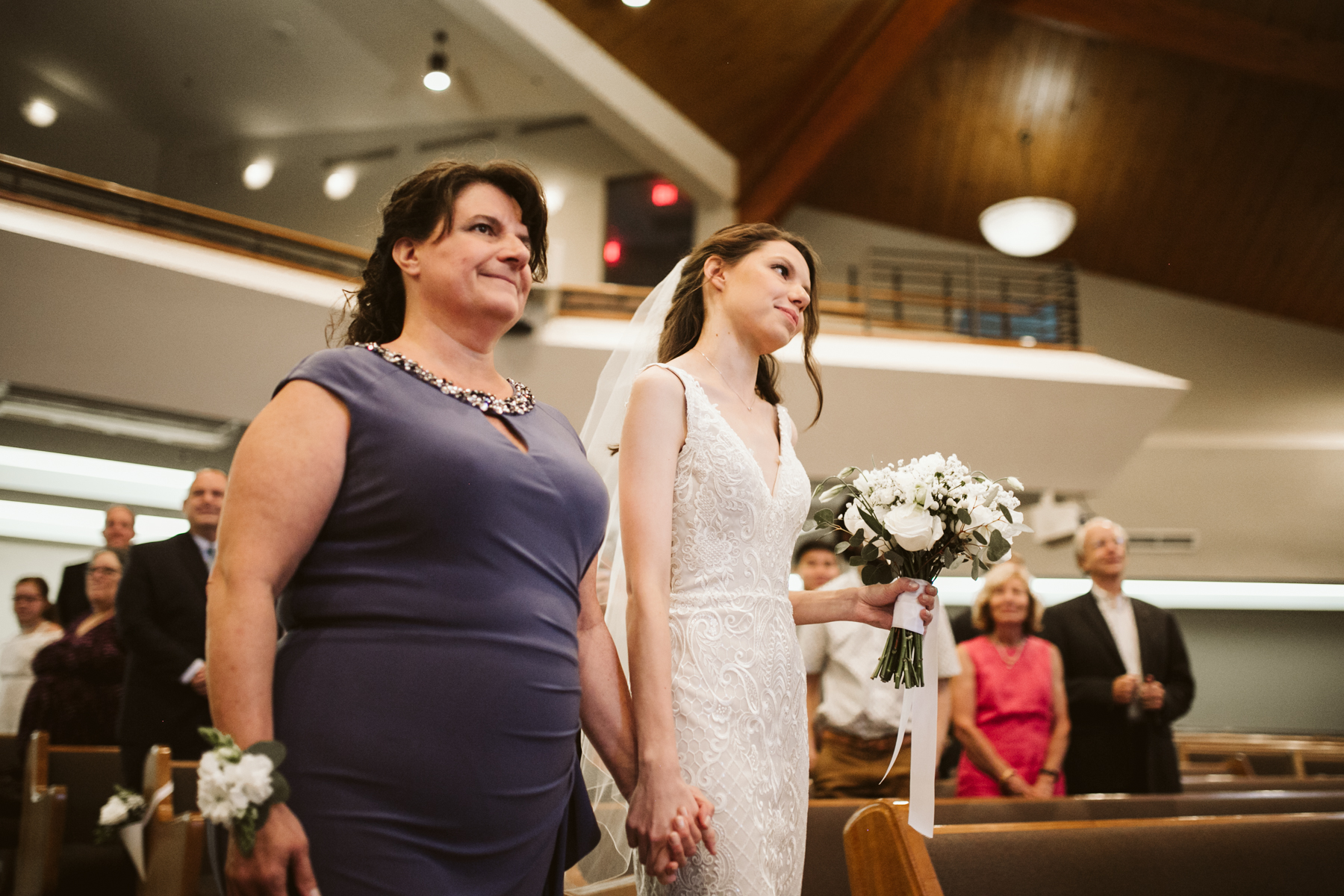 mother and daughter walk down the aisle at a rainy summer wedding at brentwood hills church in Nashville, tennessee