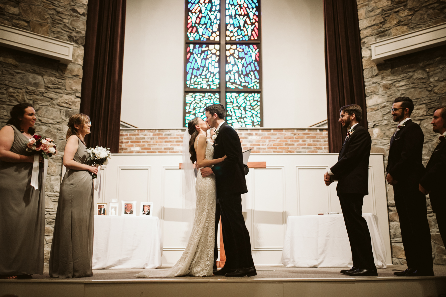 the first kiss during a rainy summer wedding at brentwood hills church in Nashville, tennessee