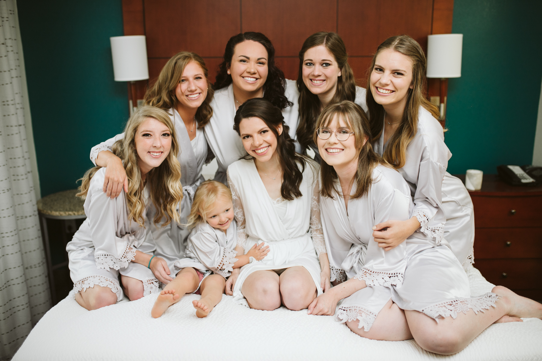 bridesmaids sit together in robes before a rainy summer wedding at brentwood hills church in Nashville, tennessee