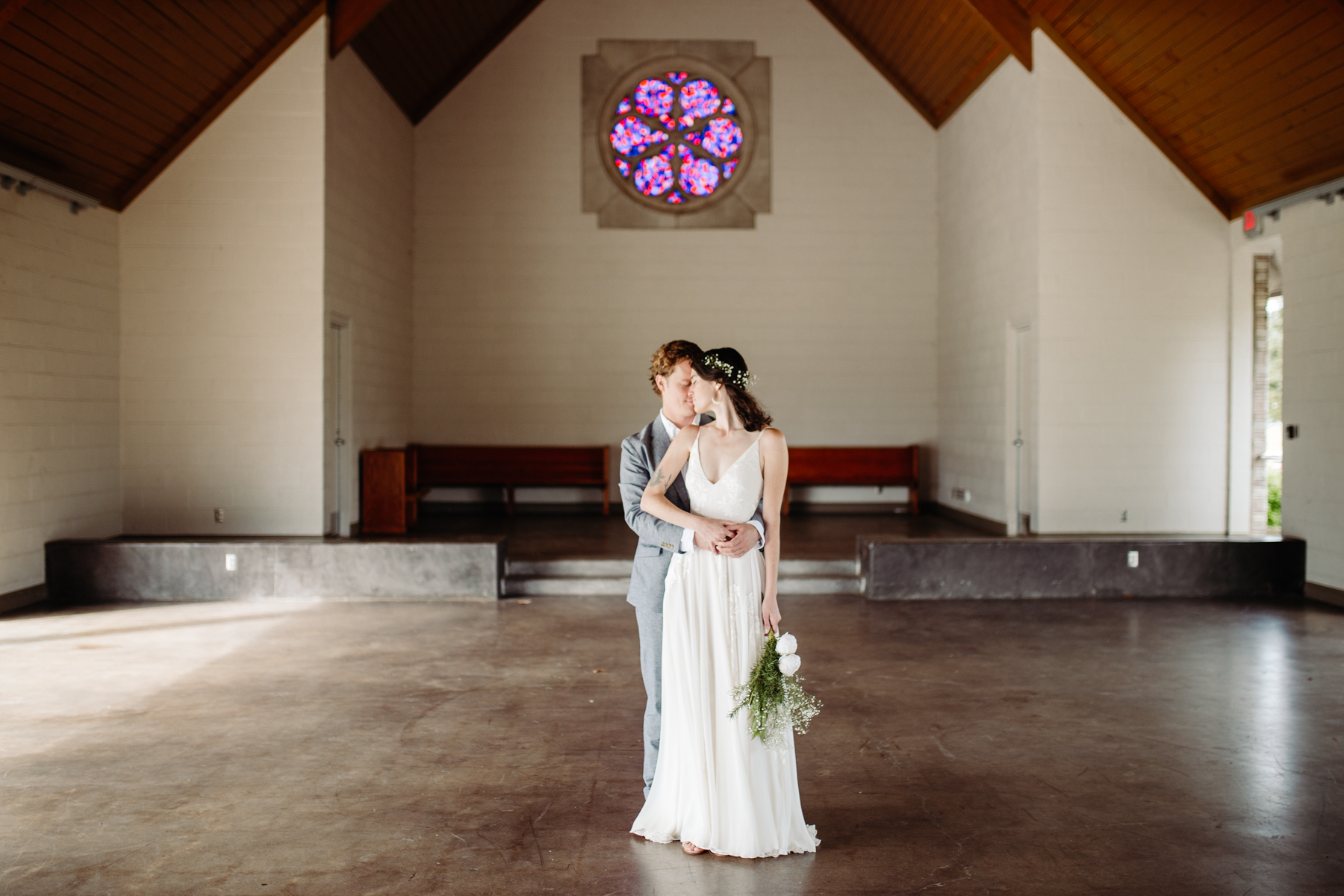 bride and groom posing inside of lakeshore chapel before their downtown knoxville wedding at redeemer church