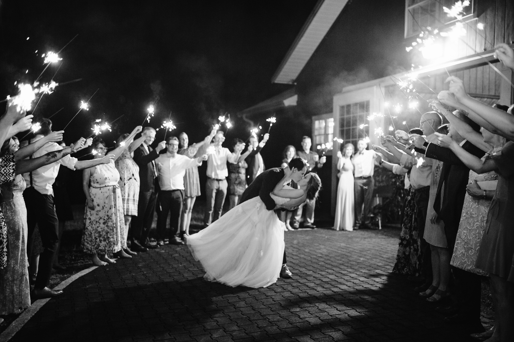 Dip kiss during a sparker exit at a stables at strawberry creek wedding in knoxville, tennessee