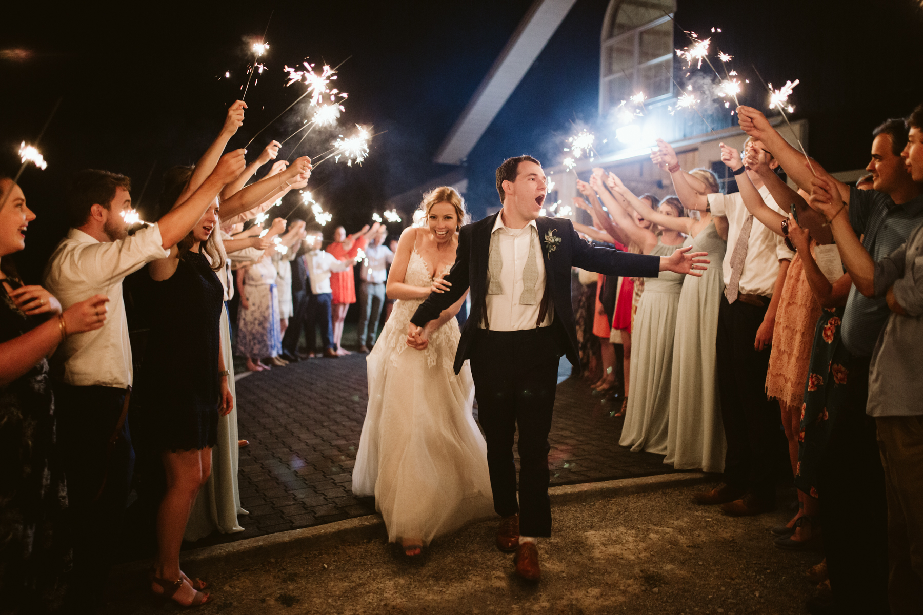 Bride and groom at a lively sparkler exit after their stables at strawberry creek wedding in knoxville, tennessee