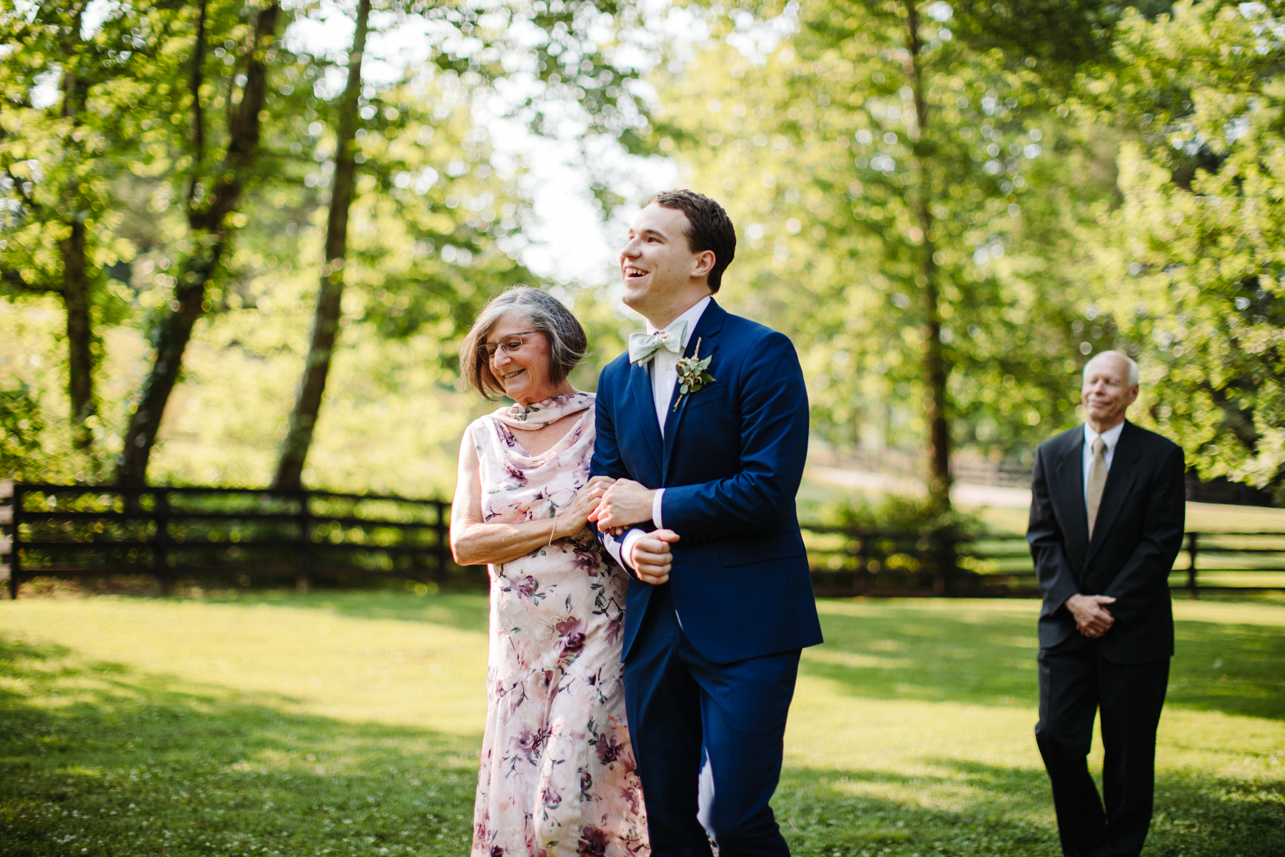 Groom walks his mother down the aisle at a stables at strawberry creek wedding in knoxville, tennessee
