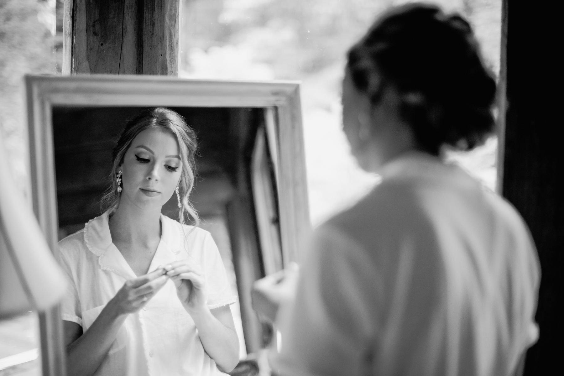 bride putting in her earrings before her stables at strawberry creek wedding in Knoxville, tennessee
