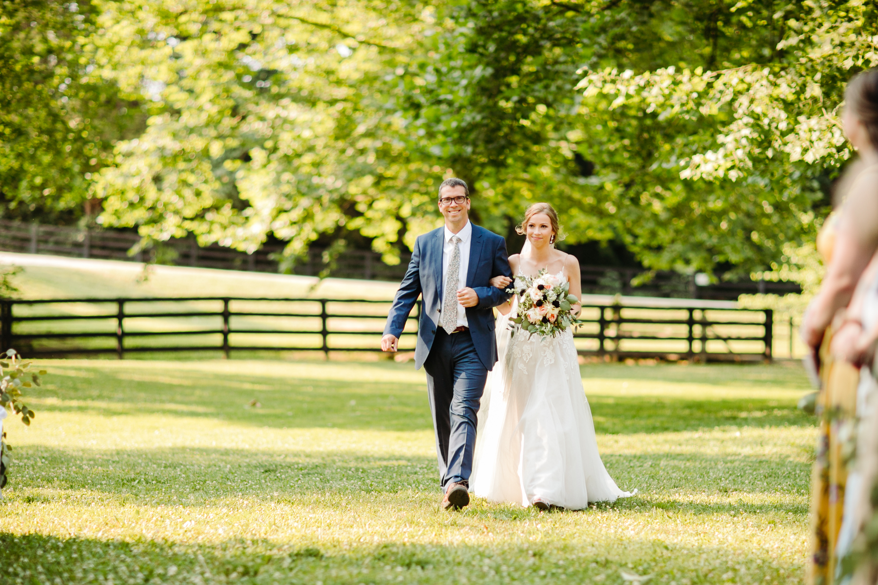 Father walking his daughter down the aisle at her stables at strawberry creek wedding in knoxville, tennessee