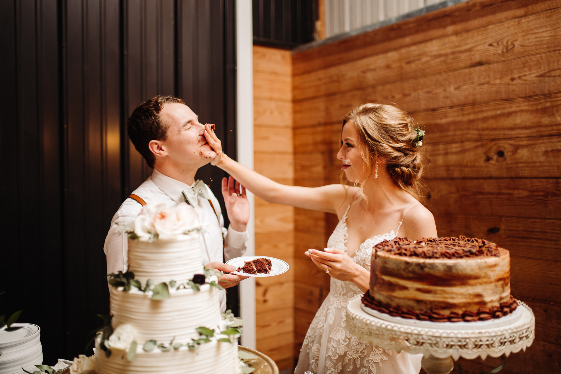 Bride smashes cake on her groom's face at their stables at strawberry creek wedding in knoxville, tennessee