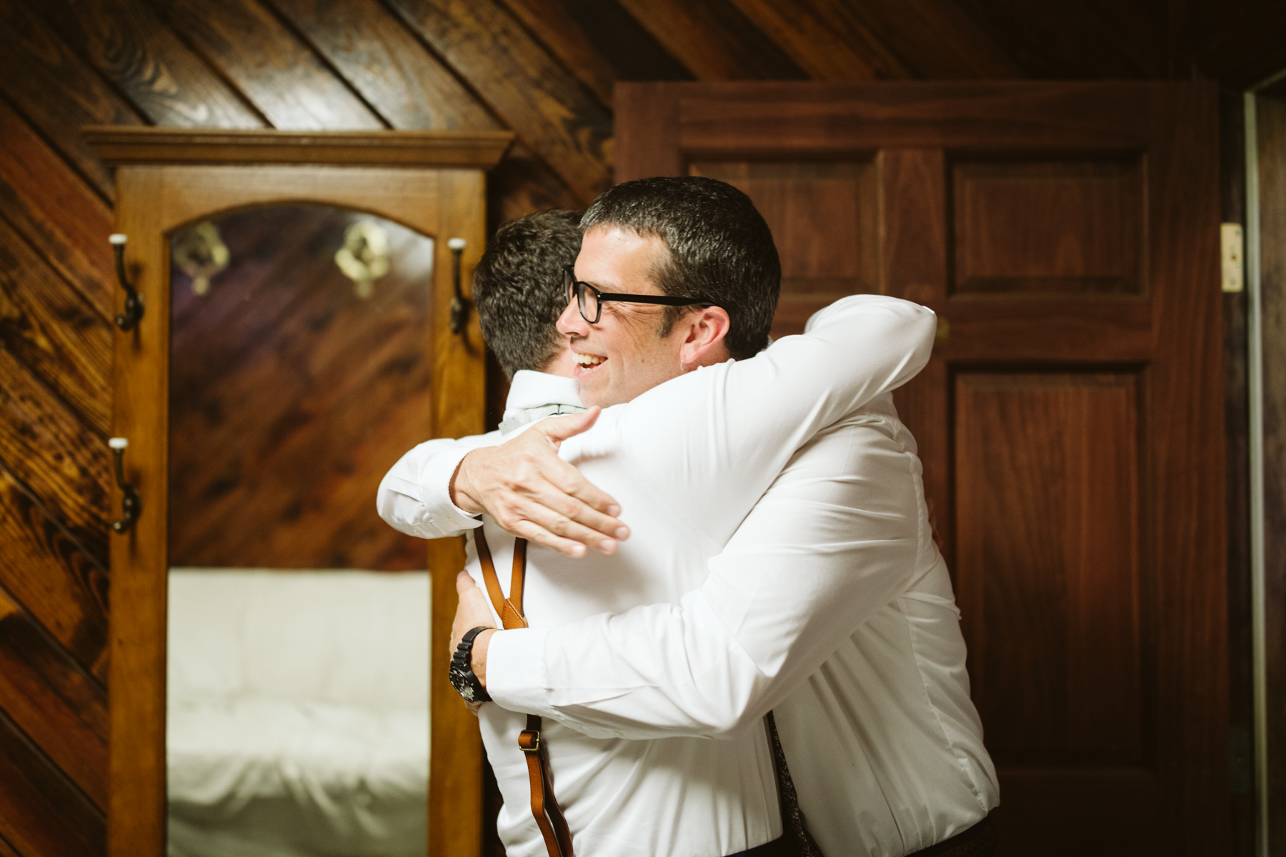 groom and father of the bride hugging before a stables at strawberry creek wedding in Knoxville, tennessee