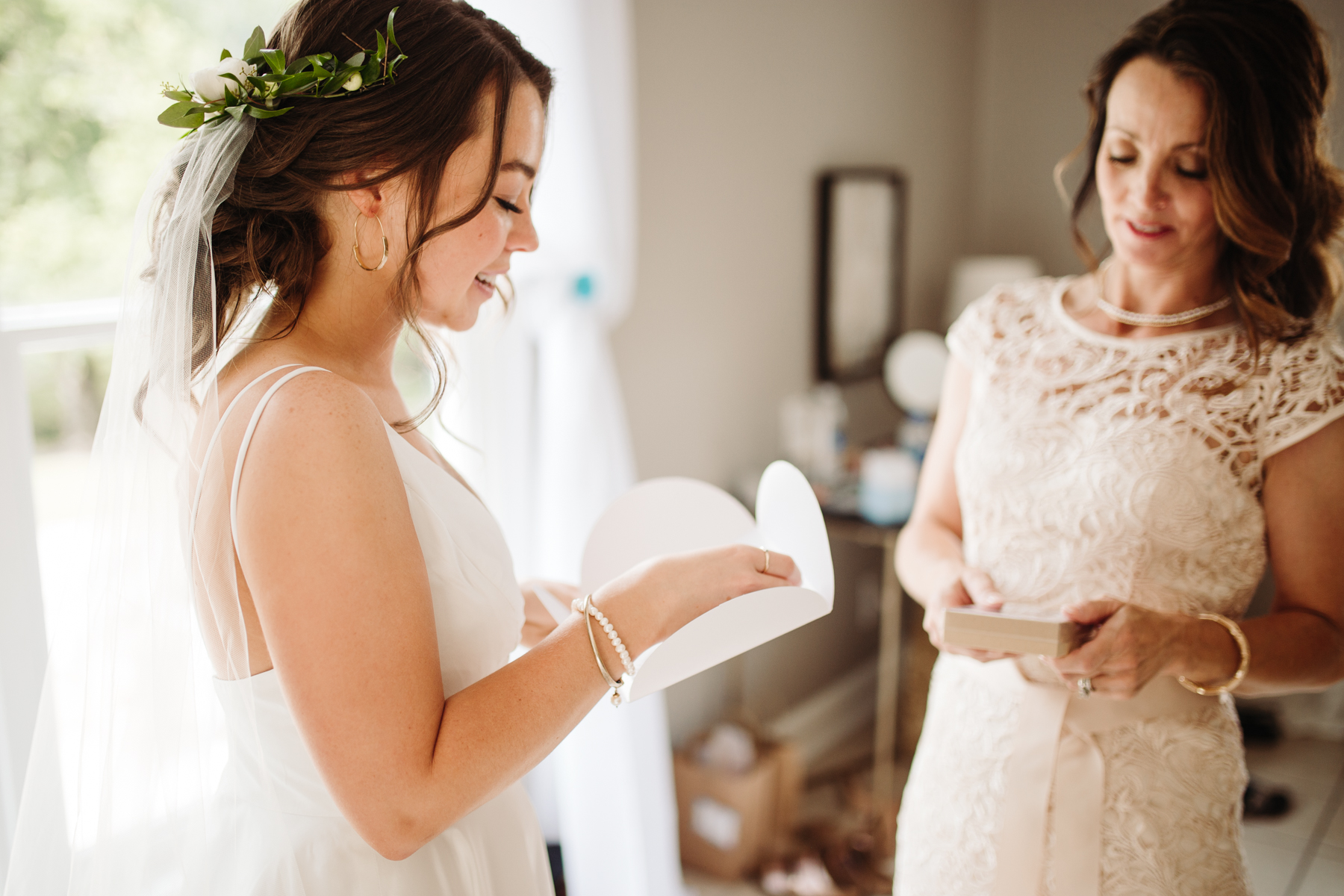 Bride and her mother swapping letters before a Sunny summer wedding at Dara's Garden in Knoxville, Tennessee 