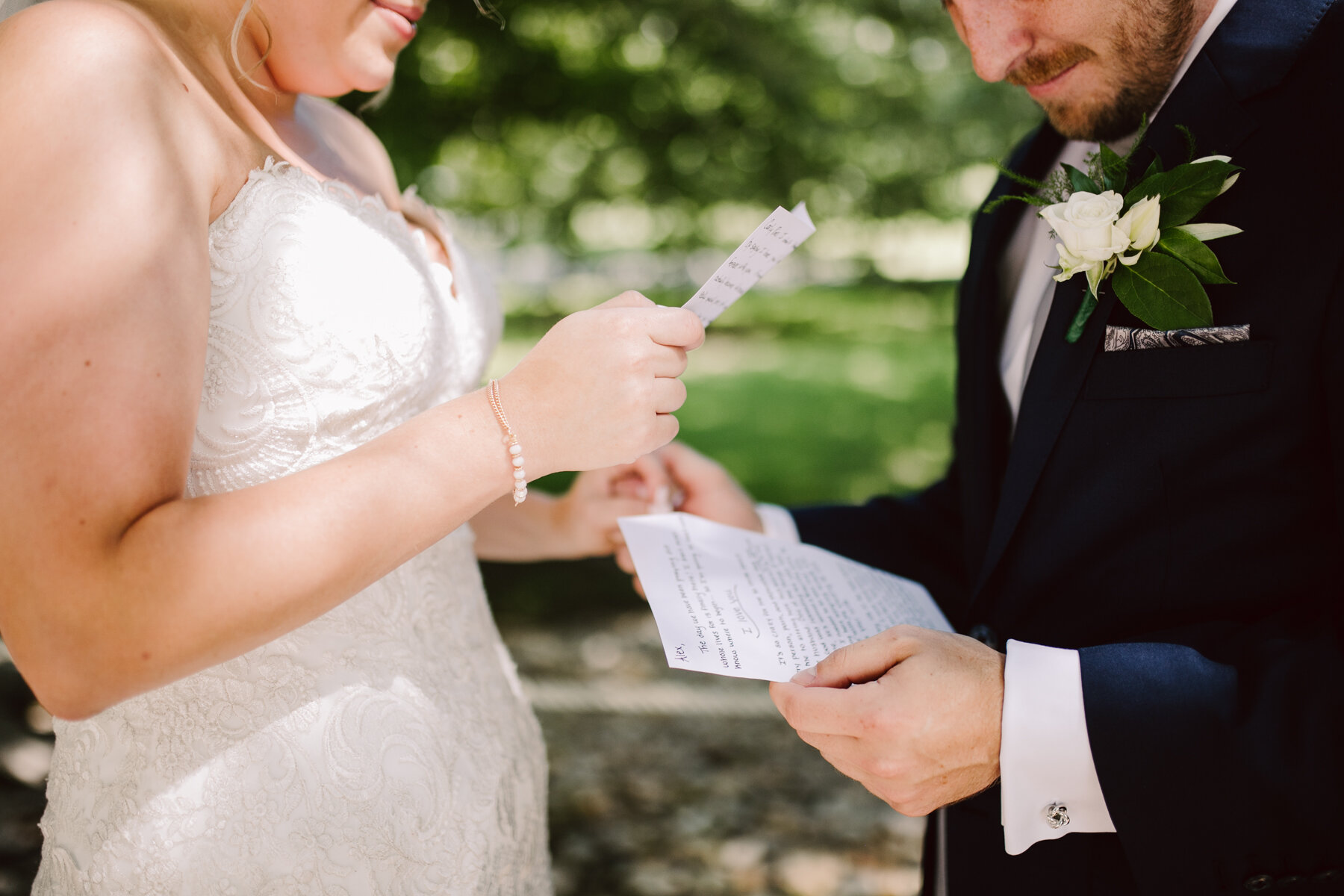 bride and groom reading letters exchanged during their first look before a sunny outdoor wedding at hunter valley farms in knoxville tennessee