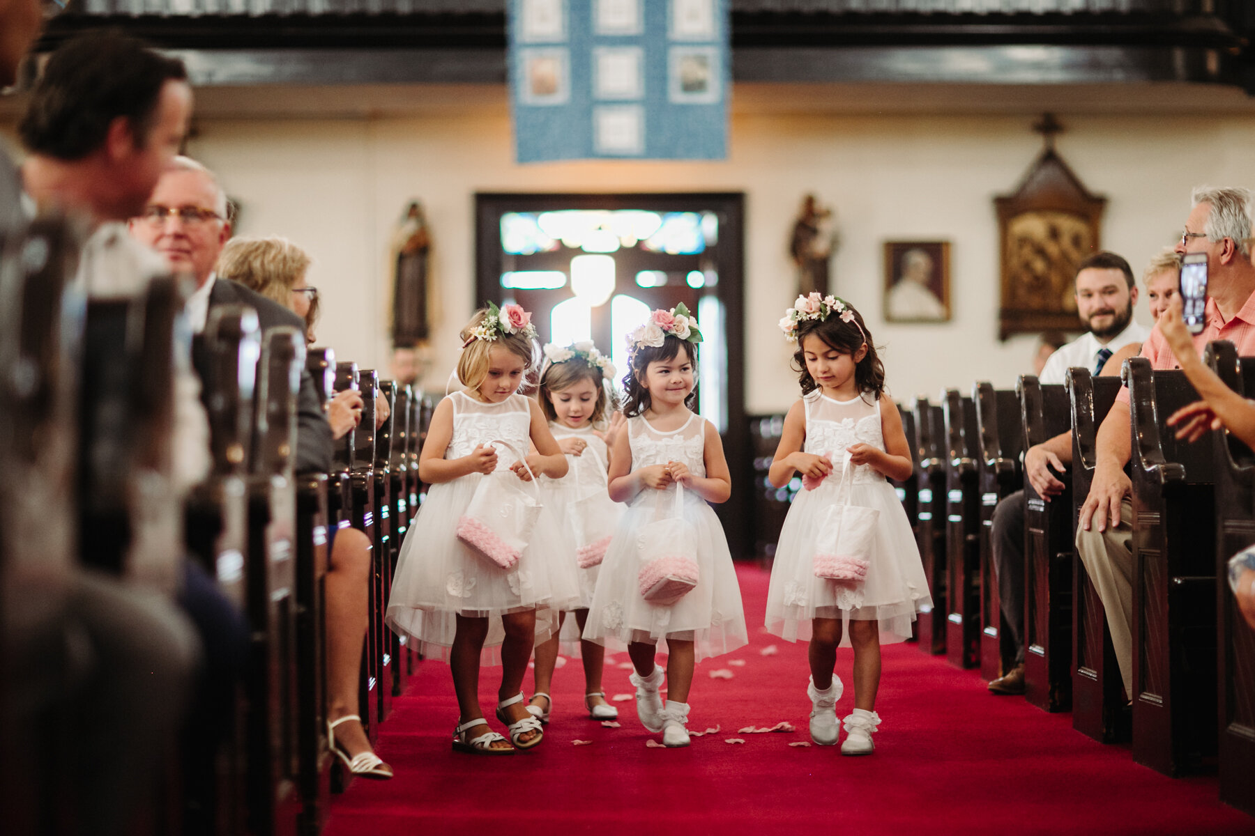flower girls coming down the aisle at an elegant indoor summer wedding in Tennessee